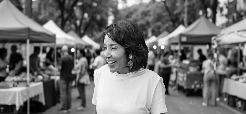 Lúcia Rosim caminhando pela feira livre, ouvindo os moradores